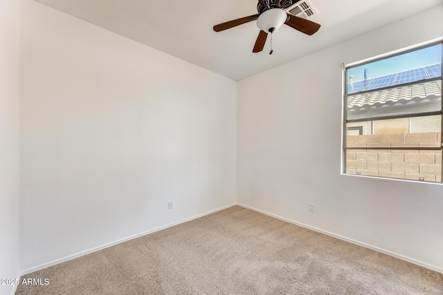empty room featuring ceiling fan, baseboards, visible vents, and carpet floors