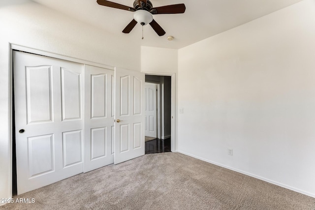 unfurnished bedroom with a closet, baseboards, a ceiling fan, and carpet