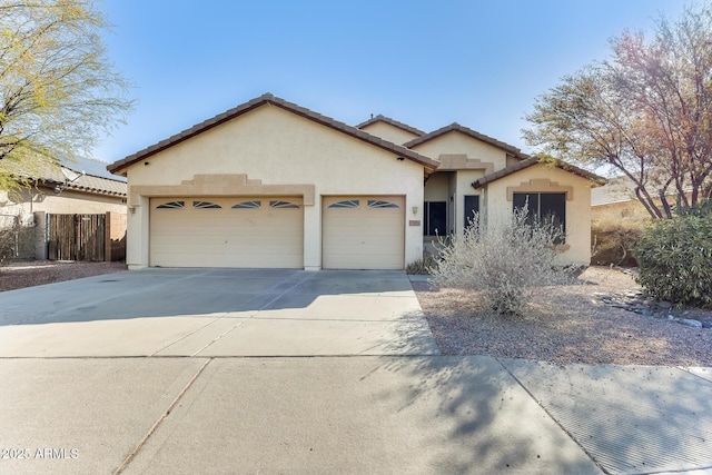 ranch-style home with a tiled roof, an attached garage, fence, concrete driveway, and stucco siding