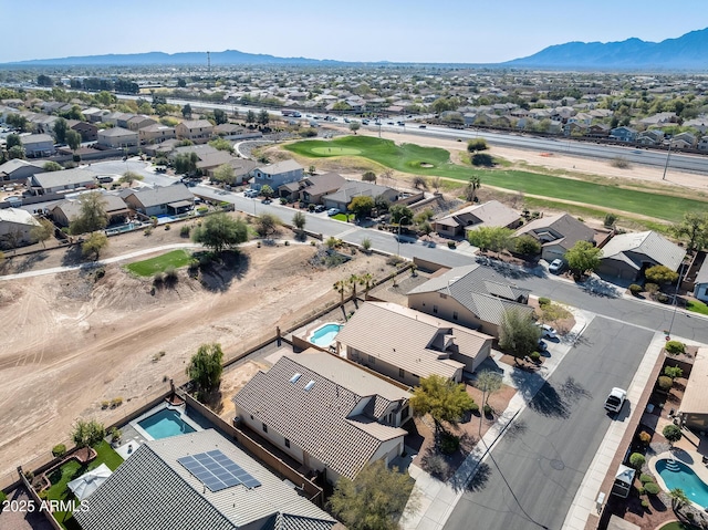drone / aerial view featuring a mountain view, view of golf course, and a residential view