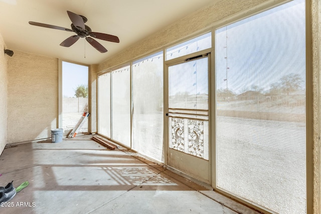 unfurnished sunroom with ceiling fan