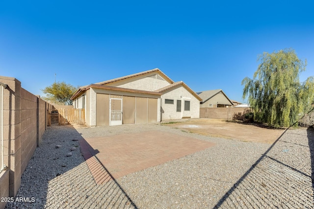 view of front of home with a patio, a fenced backyard, and stucco siding
