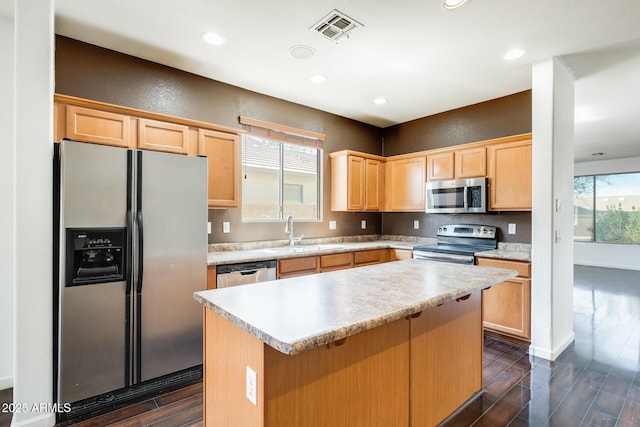 kitchen with light brown cabinets, visible vents, dark wood finished floors, stainless steel appliances, and a sink