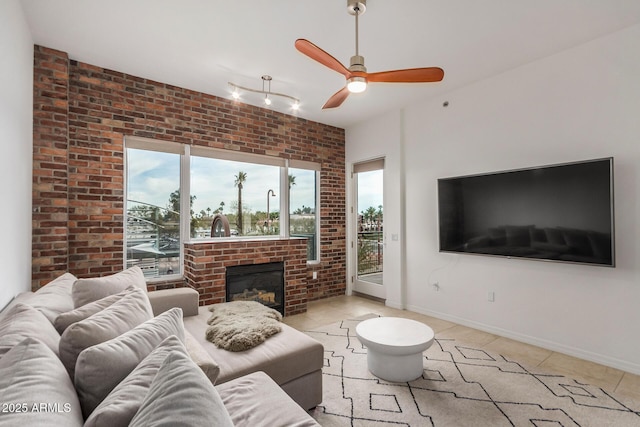 2302 N Central Ave Unit 206, Phoenix, AZ 85004 - living room featuring plenty of natural light, a ceiling fan, brick wall, a fireplace, and tile patterned flooring