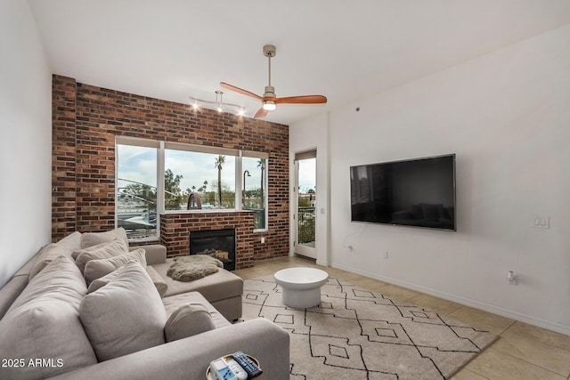2302 N Central Ave Unit 206, Phoenix, AZ 85004 - living room featuring ceiling fan, light tile patterned floors, a brick fireplace, baseboards, and brick wall