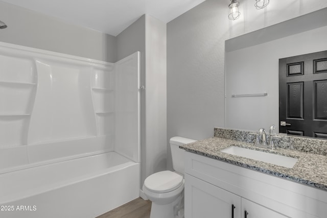 full bathroom featuring shower / washtub combination, hardwood / wood-style floors, vanity, and toilet