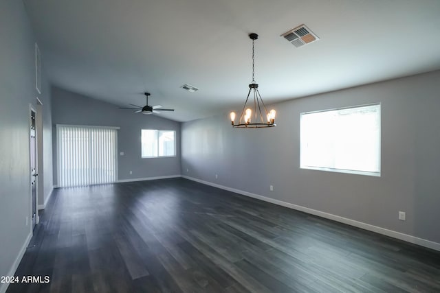 empty room featuring ceiling fan with notable chandelier, dark hardwood / wood-style floors, and vaulted ceiling