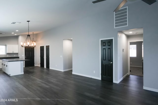 kitchen featuring pendant lighting, high vaulted ceiling, white cabinetry, dark hardwood / wood-style flooring, and a center island