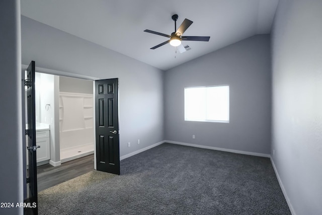 unfurnished bedroom with lofted ceiling, ceiling fan, and dark colored carpet