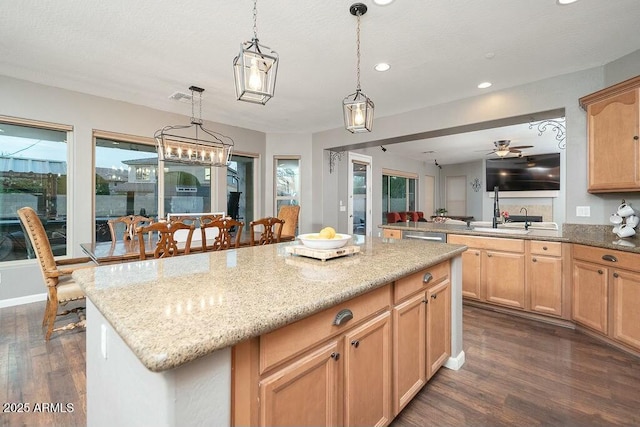 kitchen featuring a kitchen island, dark wood finished floors, light stone counters, recessed lighting, and hanging light fixtures