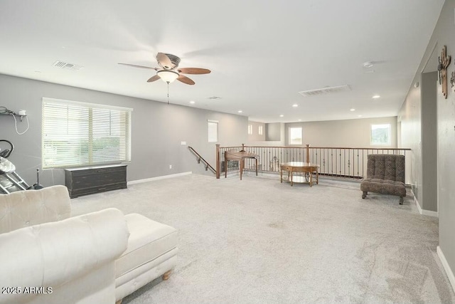 living area featuring visible vents, plenty of natural light, baseboards, and carpet floors