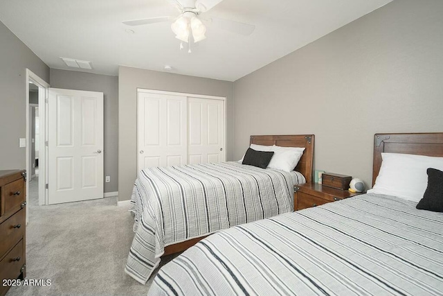 bedroom featuring a closet, visible vents, light carpet, and ceiling fan