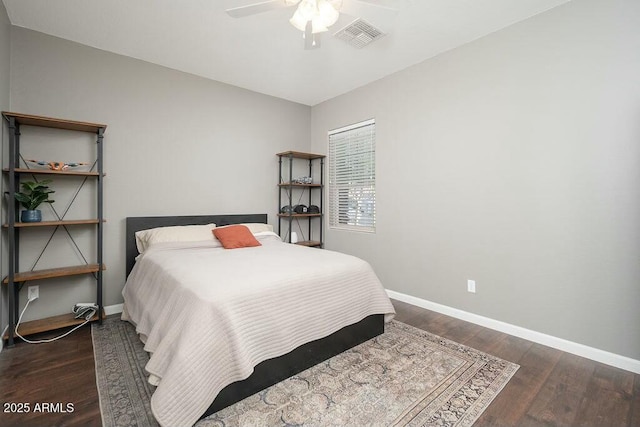 bedroom featuring visible vents, ceiling fan, baseboards, and wood finished floors