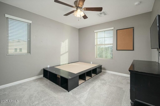 carpeted bedroom featuring visible vents, baseboards, and a ceiling fan