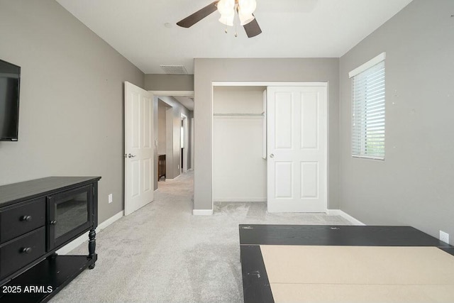 carpeted bedroom featuring a ceiling fan, baseboards, visible vents, and a closet