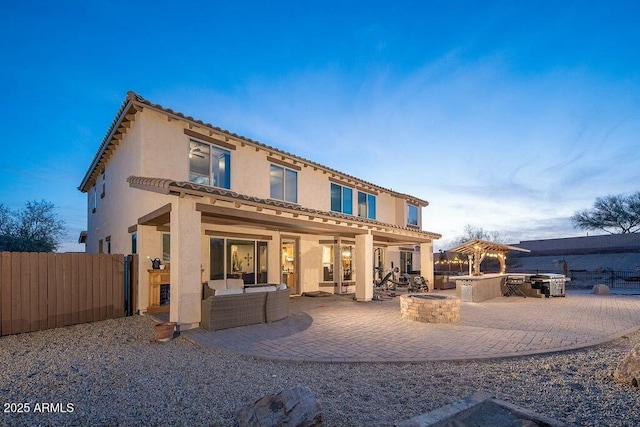 rear view of property featuring stucco siding, outdoor lounge area, a patio, and fence