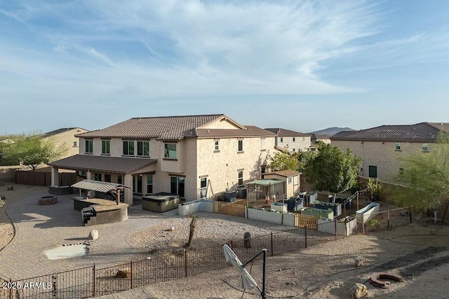 back of property featuring a patio, a fenced backyard, stucco siding, an outdoor structure, and a tile roof