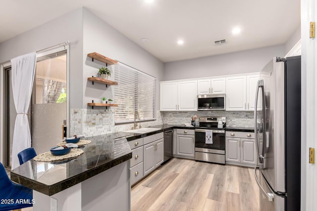 1925 W Olive Way, Chandler, AZ 85248 - kitchen featuring appliances with stainless steel finishes, a peninsula, tile counters, a sink, and tasteful backsplash