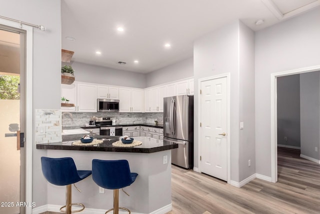 1925 W Olive Way, Chandler, AZ 85248 - kitchen featuring appliances with stainless steel finishes, a peninsula, open shelves, decorative backsplash, and white cabinetry
