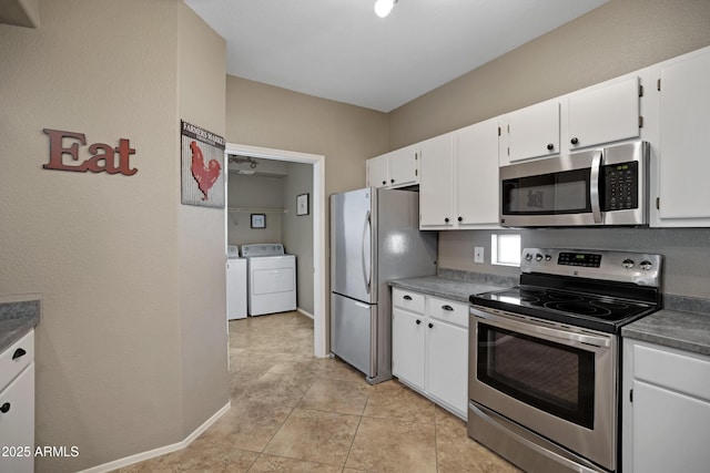 3236 E Chandler Blvd Unit 2018, Phoenix, AZ 85048 - kitchen featuring appliances with stainless steel finishes, washer and clothes dryer, white cabinets, and dark countertops