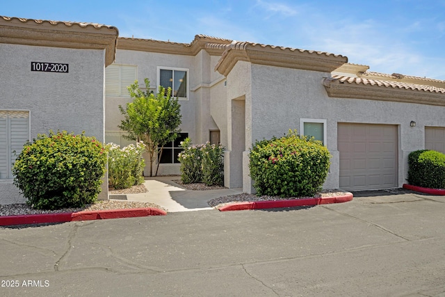 3236 E Chandler Blvd Unit 2018, Phoenix, AZ 85048 - view of front of property with stucco siding, a garage, and a tiled roof