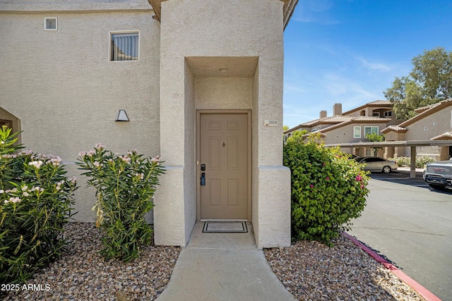3236 E Chandler Blvd Unit 2018, Phoenix, AZ 85048 - doorway to property featuring stucco siding and covered parking