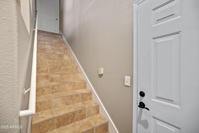 3236 E Chandler Blvd Unit 2018, Phoenix, AZ 85048 - stairway featuring stone tile floors and a textured wall