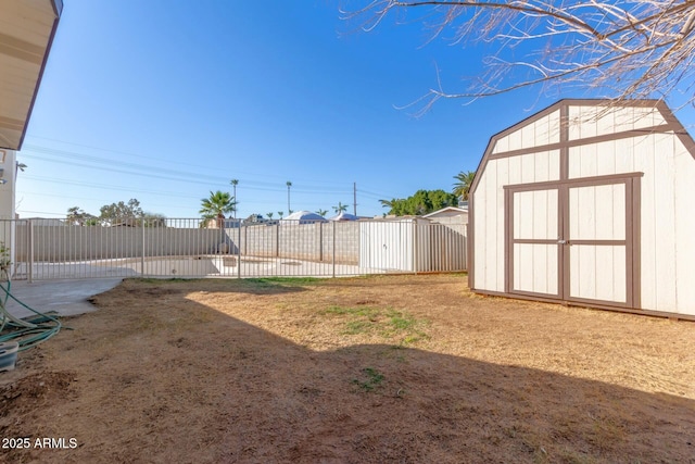 view of yard with a storage shed, fence, and an outbuilding