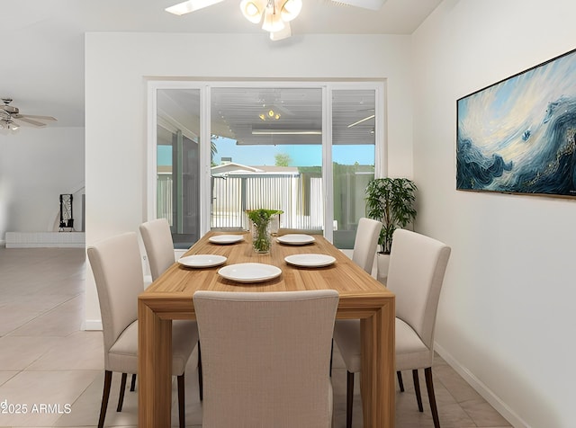 dining area featuring ceiling fan, baseboards, and light tile patterned floors