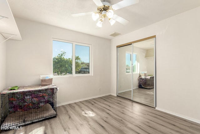 bedroom featuring a closet, wood finished floors, visible vents, and baseboards