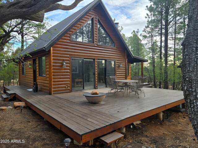2028 Jones Pass, Overgaard, AZ 85933 - rear view of property with log veneer siding, outdoor dining space, a deck, and an outdoor fire pit