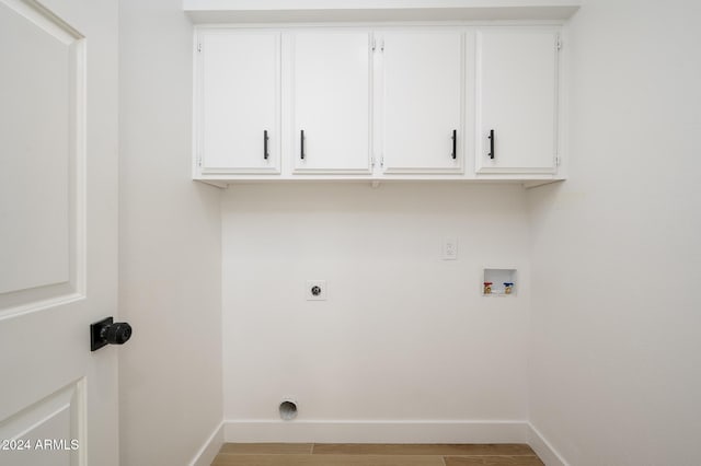 washroom with hookup for an electric dryer, cabinets, hookup for a washing machine, and light hardwood / wood-style flooring