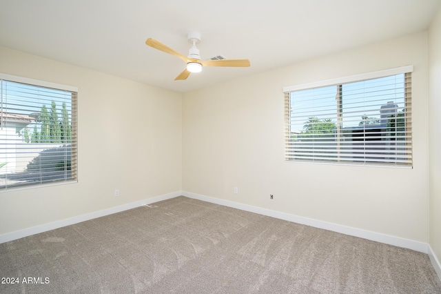 spare room featuring ceiling fan, carpet floors, and a wealth of natural light