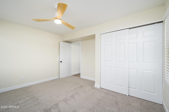 unfurnished bedroom with light carpet, a closet, and ceiling fan