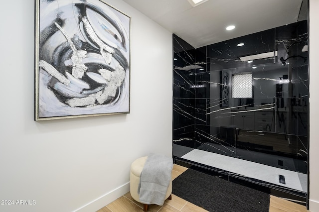 bathroom with tiled shower and hardwood / wood-style flooring