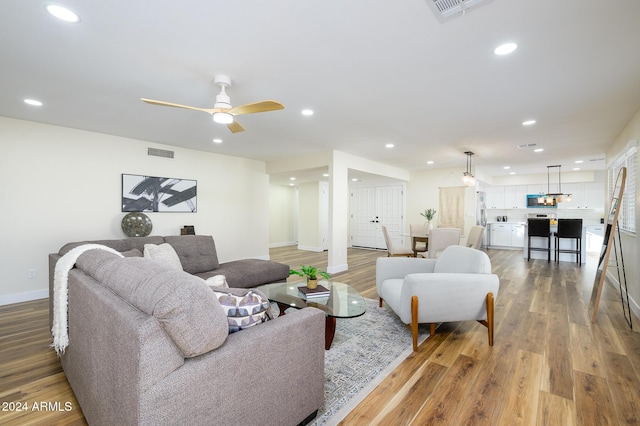 living room featuring hardwood / wood-style floors and ceiling fan