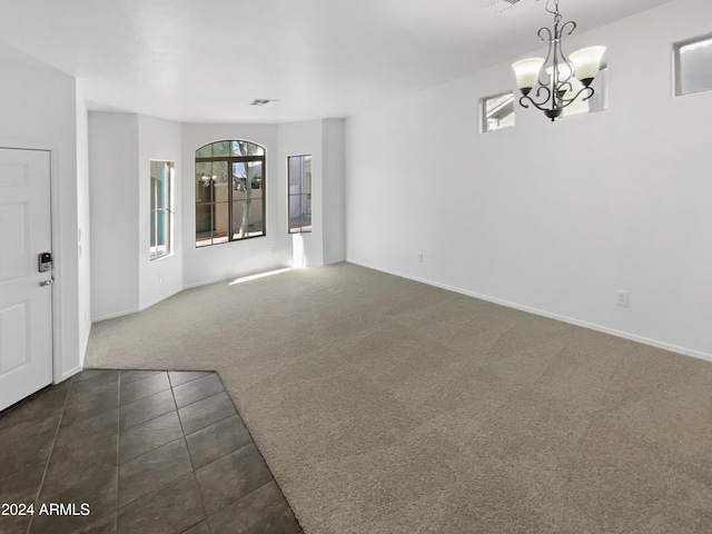 interior space featuring dark colored carpet and a chandelier