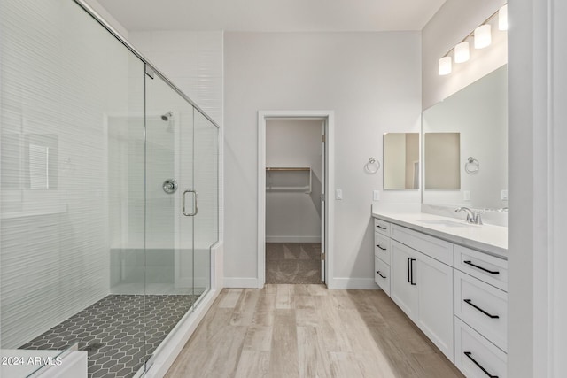 bathroom featuring a shower with door, vanity, and hardwood / wood-style flooring