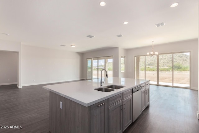 kitchen with pendant lighting, sink, dishwasher, a kitchen island with sink, and dark hardwood / wood-style floors