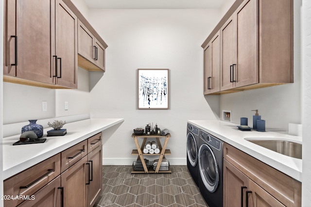 laundry area featuring separate washer and dryer, sink, and cabinets