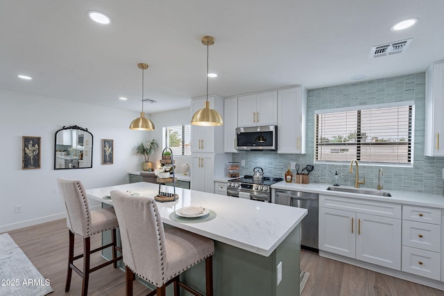 7715 N 13th St, Phoenix, AZ 85020 - kitchen with a sink, stainless steel appliances, a kitchen breakfast bar, decorative backsplash, and a center island