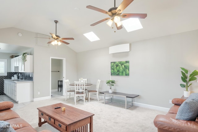 carpeted living room with ceiling fan, vaulted ceiling with skylight, a wall mounted air conditioner, and sink