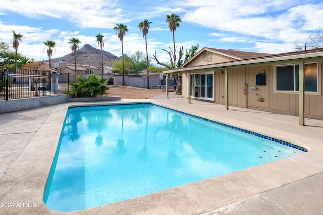 view of swimming pool with a mountain view and a patio area