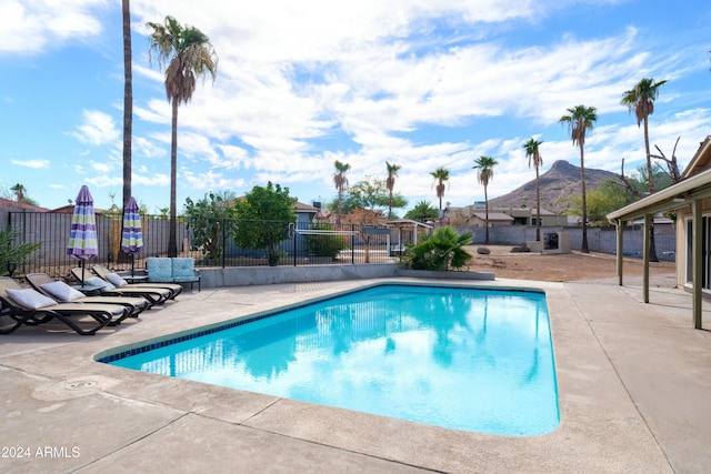 view of swimming pool with a mountain view and a patio