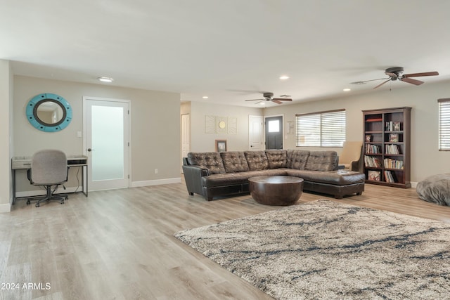 living room featuring ceiling fan and light hardwood / wood-style floors