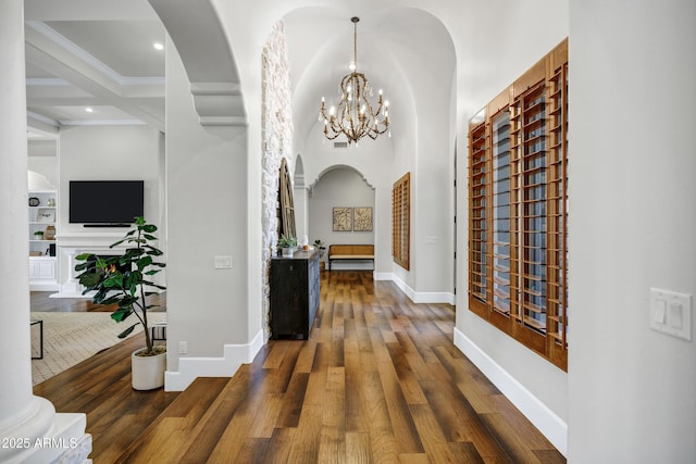 2527 E Beechnut Ct, Chandler, AZ 85249 - corridor featuring a chandelier, arched walkways, built in shelves, wood finished floors, and beam ceiling