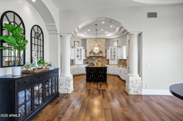 2527 E Beechnut Ct, Chandler, AZ 85249 - hallway featuring decorative columns, arched walkways, dark wood finished floors, a raised ceiling, and recessed lighting