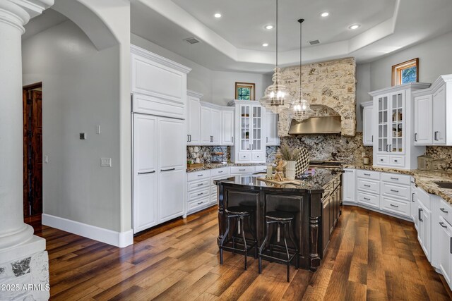 2527 E Beechnut Ct, Chandler, AZ 85249 - kitchen with dark wood-style floors, a raised ceiling, arched walkways, white cabinetry, and recessed lighting