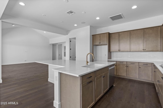 kitchen featuring visible vents, dishwasher, dark wood-style floors, a kitchen island with sink, and a sink