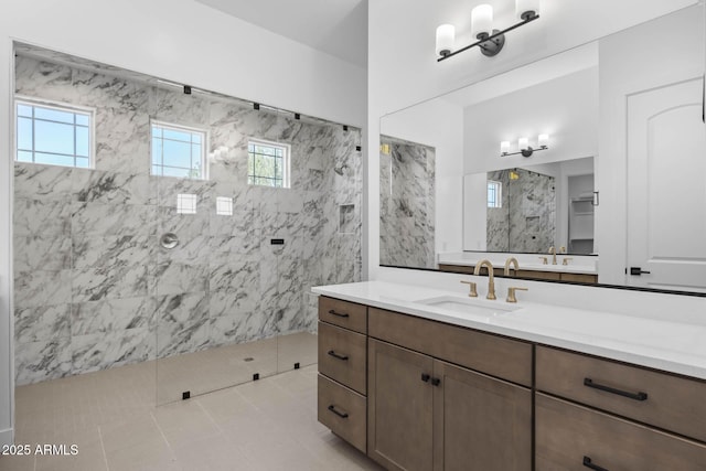 full bath featuring a marble finish shower and vanity